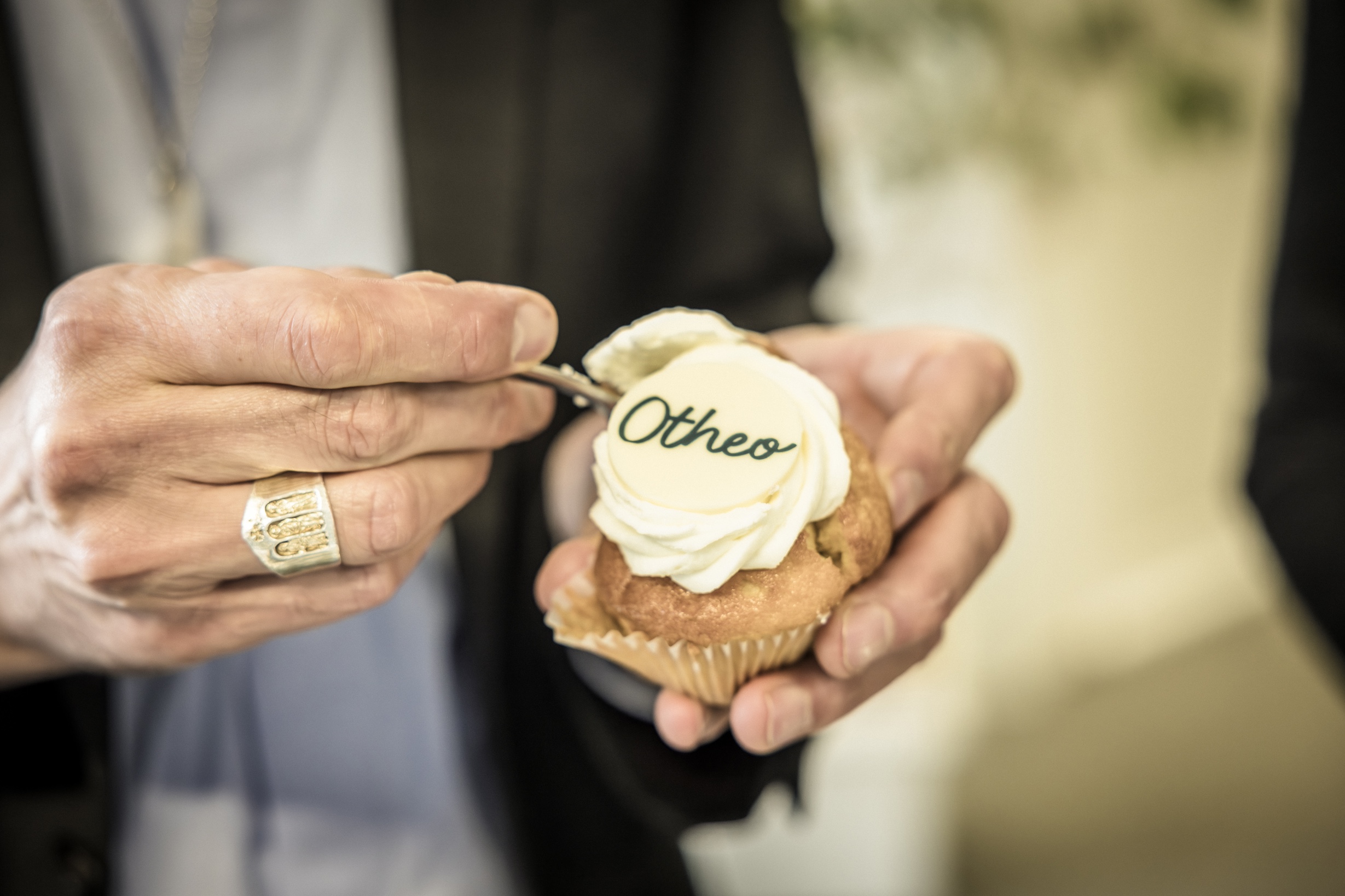 Dat smaakt naar meer. Een vinger met bisschopsring steekt het vorkje in de cupcake.