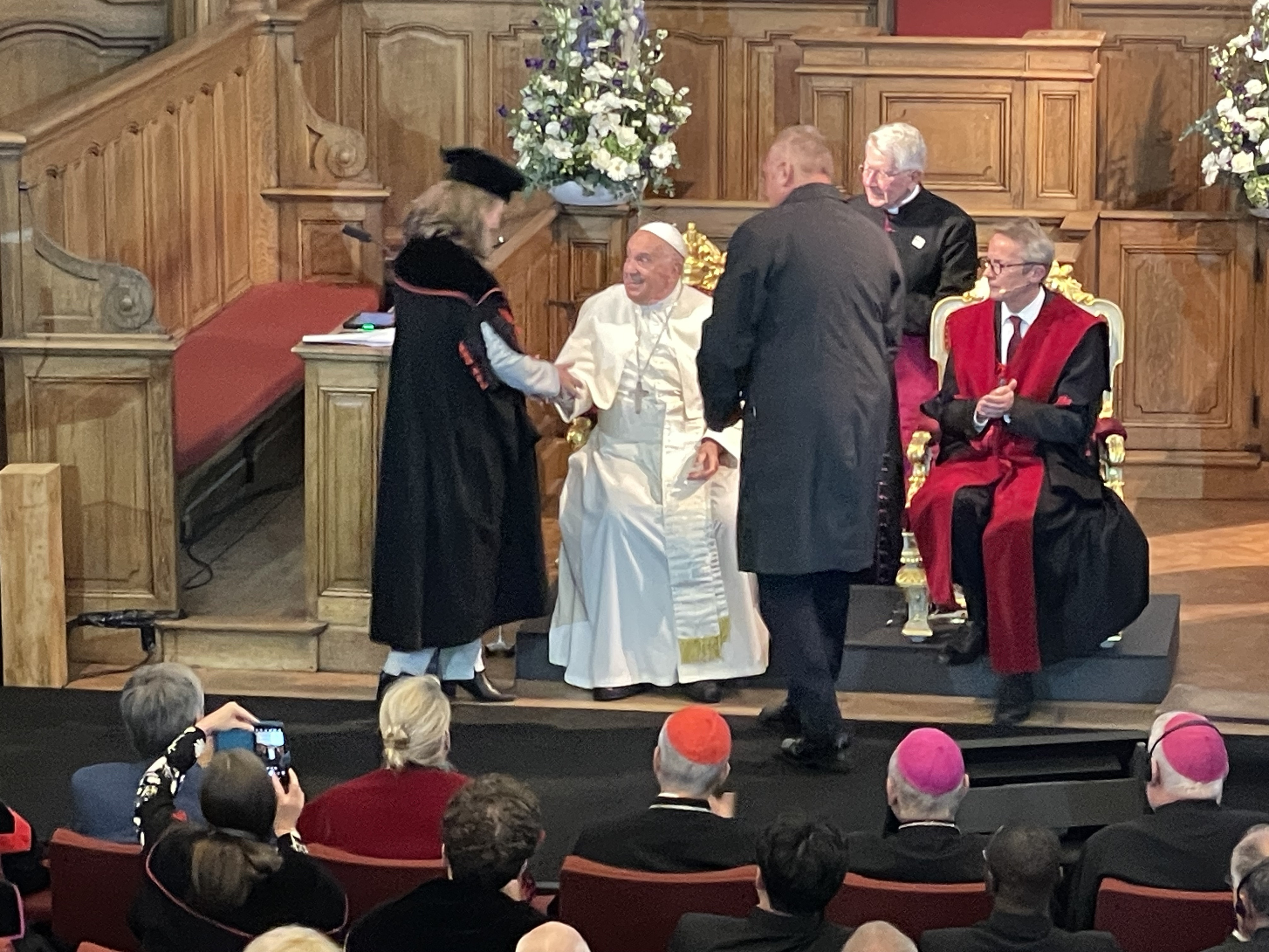 Decaan Bénédicte Lemmelijn geeft een boek van 24 theologen aan paus Franciscus. Bénédicte Lemmelijn schudt de hand van paus Franciscus.