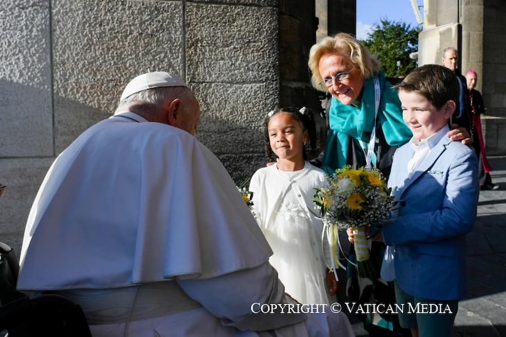 Martine Motteux en twee kinderen wachten de paus op en bieden hem gele bloemen aan Martine Motteux en twee kinderen wachten de paus op en bieden hem gele bloemen aan