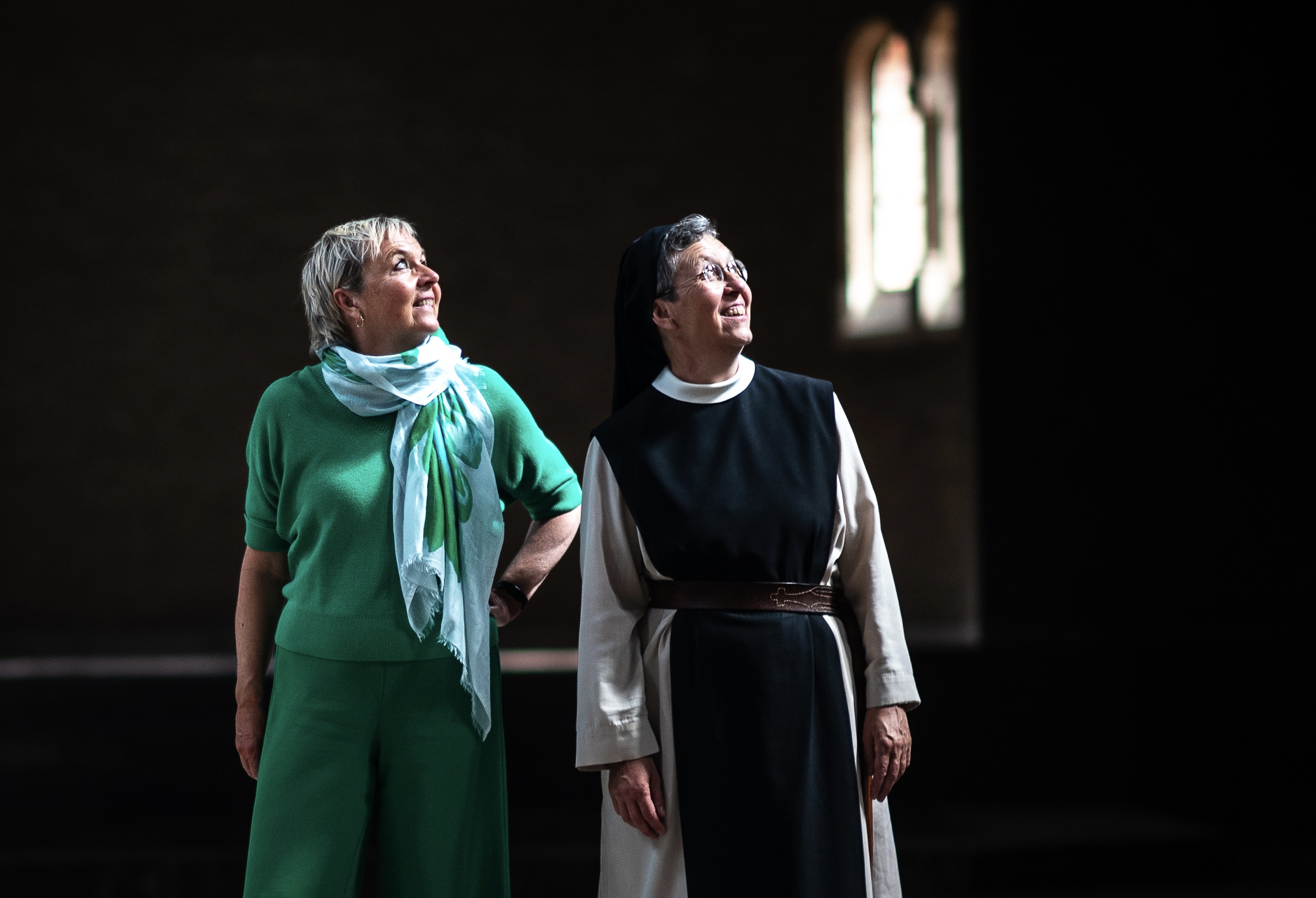 Annemie Struyf en zuster Katharina kijken allebei naar het licht dat uit het hoge raam valt.