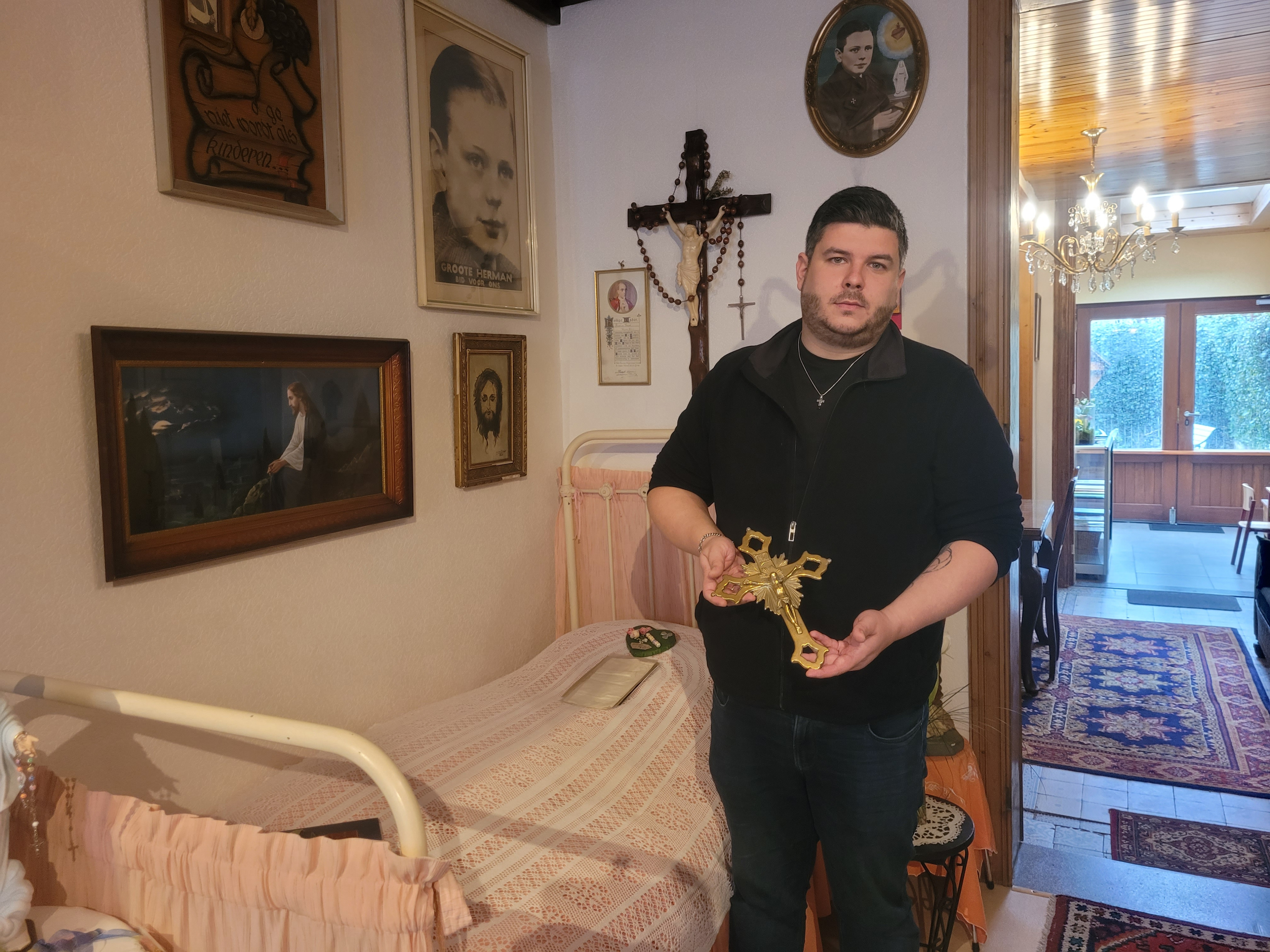 Het kruis dat op het originele bed met sprei van Herman ligt Het kruis dat op het originele bed met sprei van Herman ligt