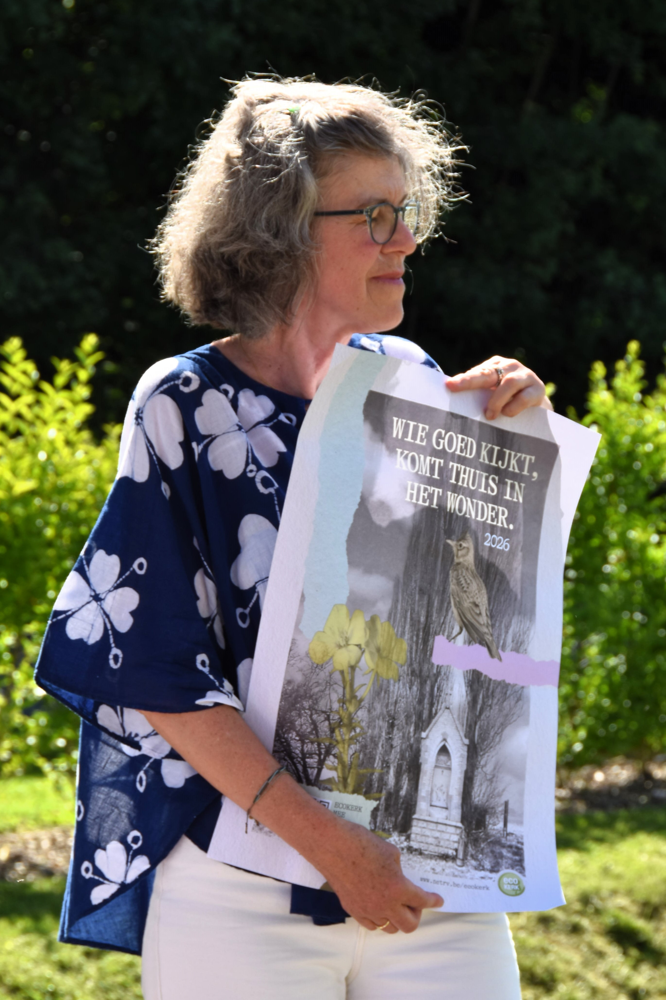 Aletta Rambaut toont de affiche van de campagne van Ecokerk voor 2026.