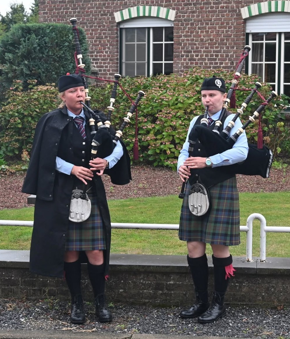 Twee doedelzakspelers in traditionele Schotse kledij met kilts en een doedelzak.