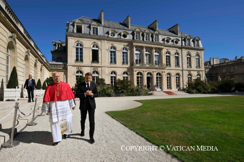 President Macron en paus Leo wandelen langs het Elysée.