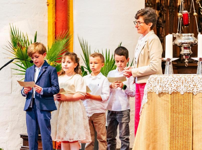 Eerste communie 2026 Een feestelijke eerste communieviering in een kerk, waarbij kinderen teksten voorlezen.