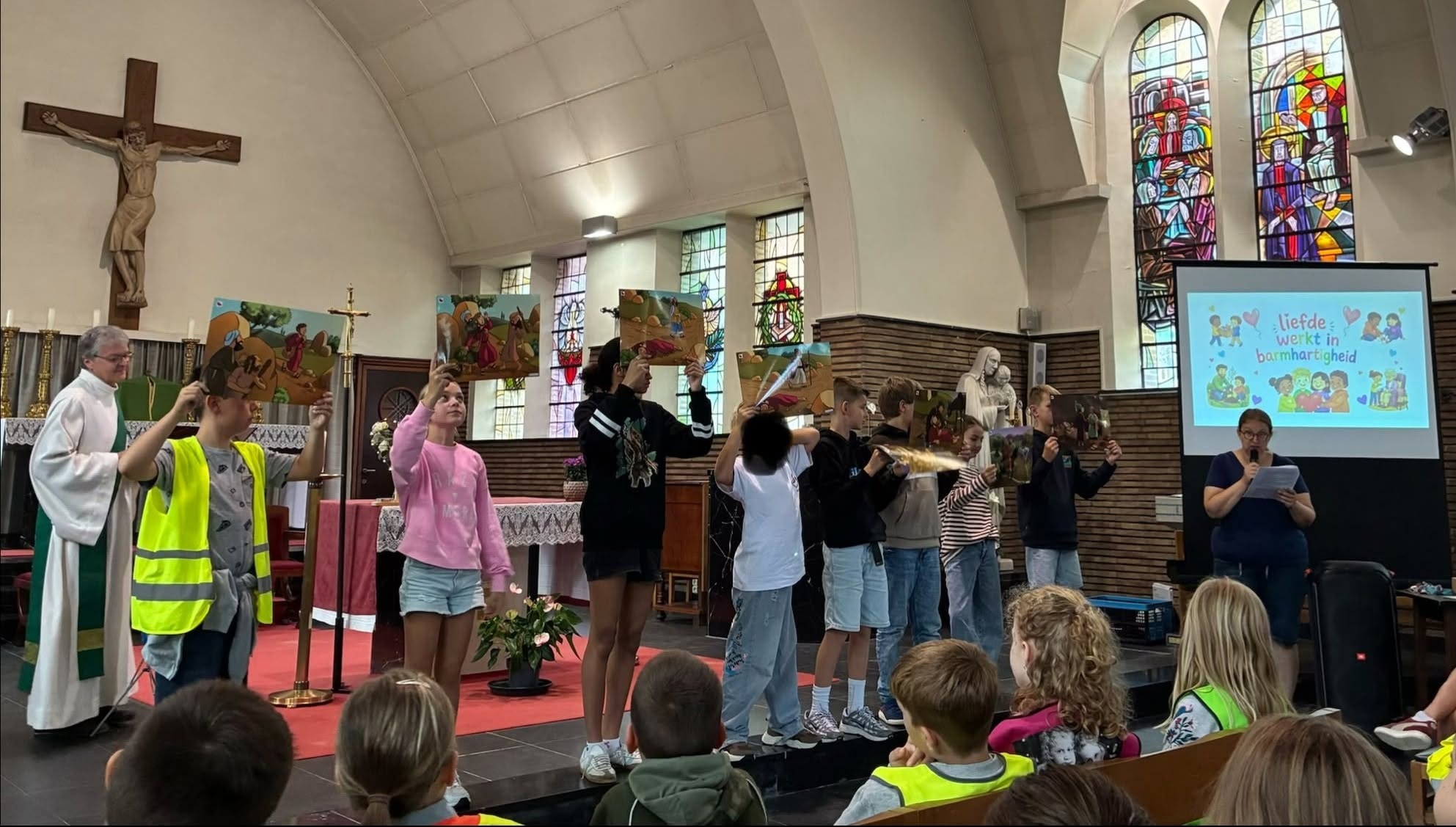 Zingende kinderen bij een startviering begin schooljaar.