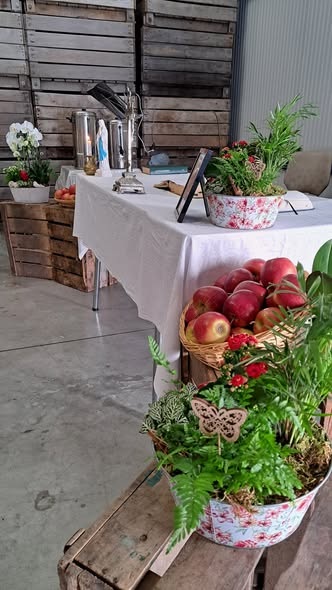 Vruchten der aarde viering Een rustieke opstelling met een gedekte tafel, houten kratten en verse appels in een mand.