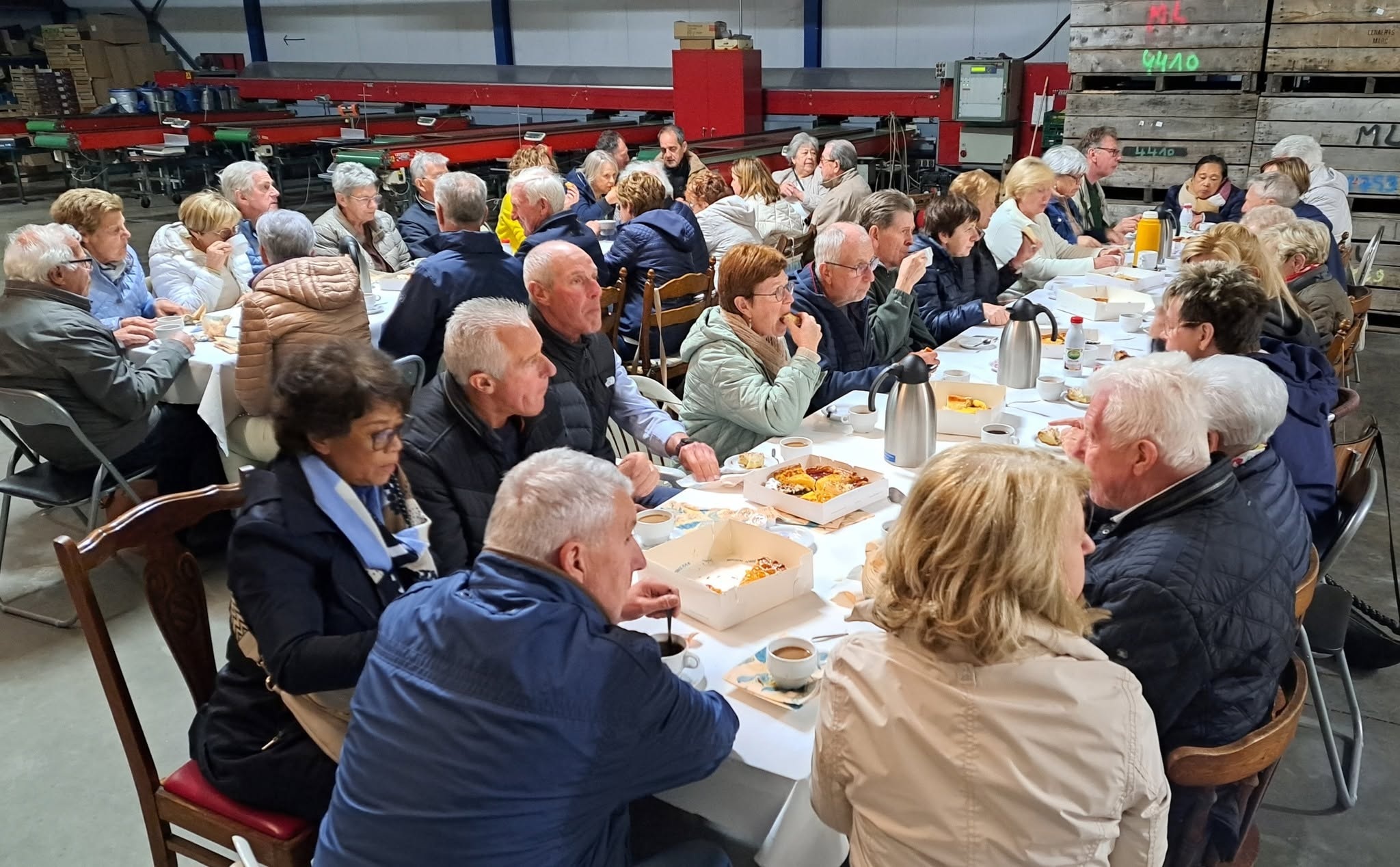 Vruchten der aarde viering Een sociale bijeenkomst of maaltijd, zoals een buurtrestaurant, een parochiefeest of een gemeenschappelijke maaltijd waar mensen samen aan gedekte tafels zitten.