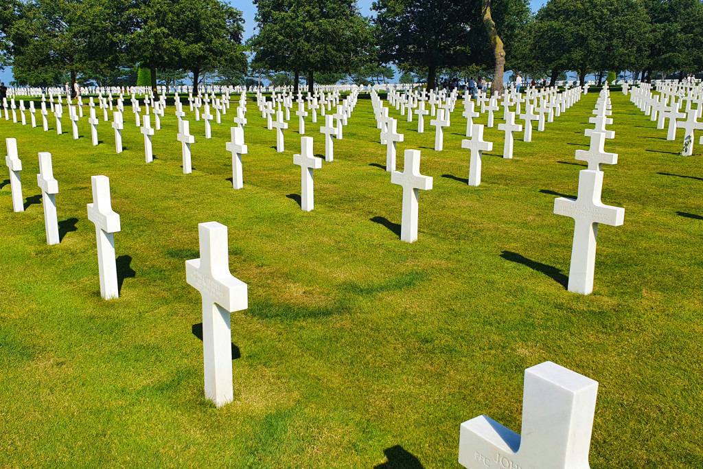 Witte kruisen in het gras, zo ver je kan zien. Beeld van Omaha Beach in Normandië.