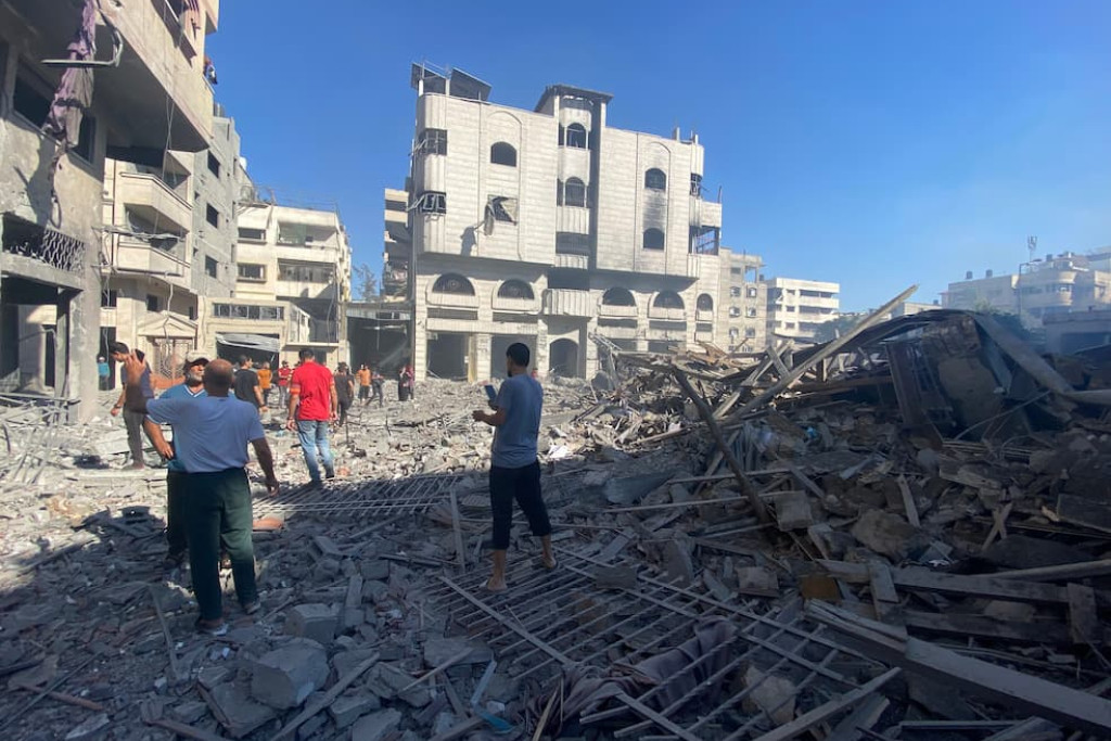 Palestijnen doorzoeken het puin van de Heilige Familieschool in Gaza na de Israëlische luchtaanval van zondagochtend 7 juli 2024