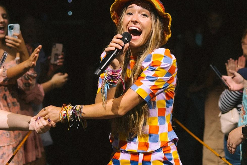 Lauren Daigle op Kaleidoscope Tour. Lauren Daigle op het podium met de Kaleidoscope Tour. Vrolijke flower power-kleuren