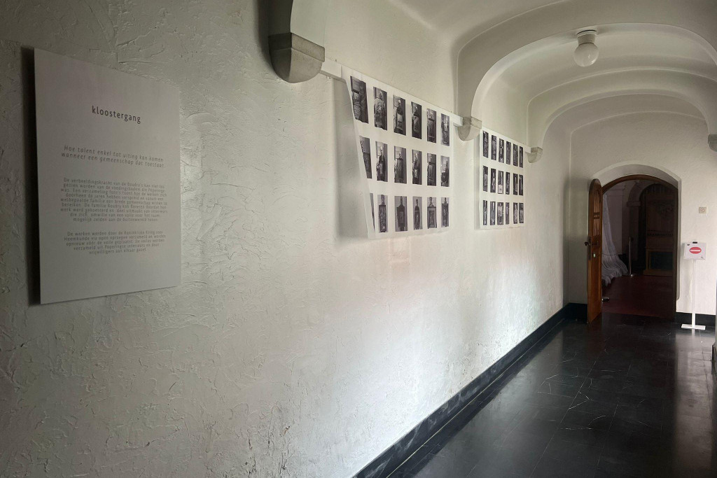 Pandgang in het klooster met foto's van de eigenaars met hun Boudrywerk op voile geprint.jpg