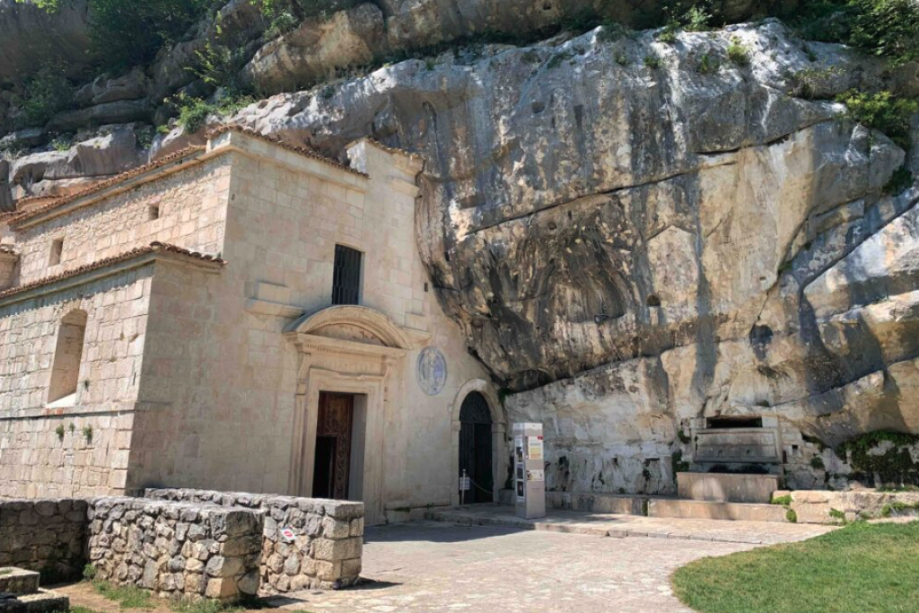 Het kluizenaarsklooster Santo Spirito a Maiella, spectaculair gelegen tegen een hoge rotswand en omgeven door een dicht beukenbos.