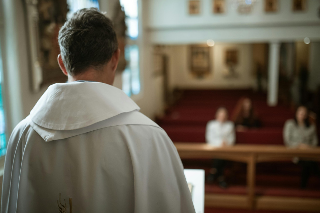 Priester van op de rug aan het altaar