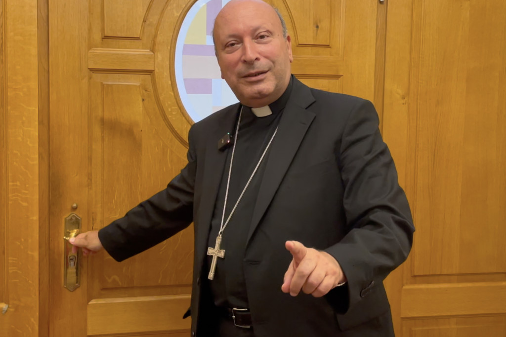 Nuntius Franco Coppola sluit de voordeur al pratend en gesticulerend.