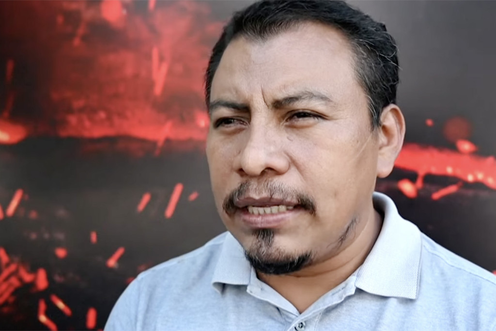 Juan Antonio López met brandend veld op de achtergrond.