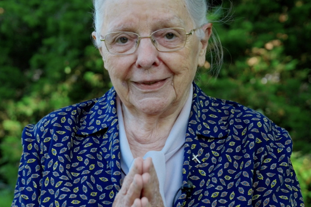 Jeanne Devos, handen gevouwen in een groet: 'Namaste'