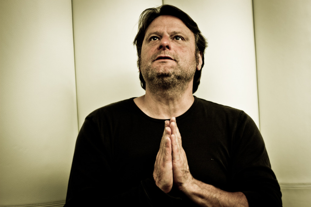 Luc De Vos sprak geregeld met kardinaal Danneels en bisschop Luc Van Looy over het christelijk geloof. Luc De Vos houdt handen gevouwen als in gebed en kijkt omhoog.