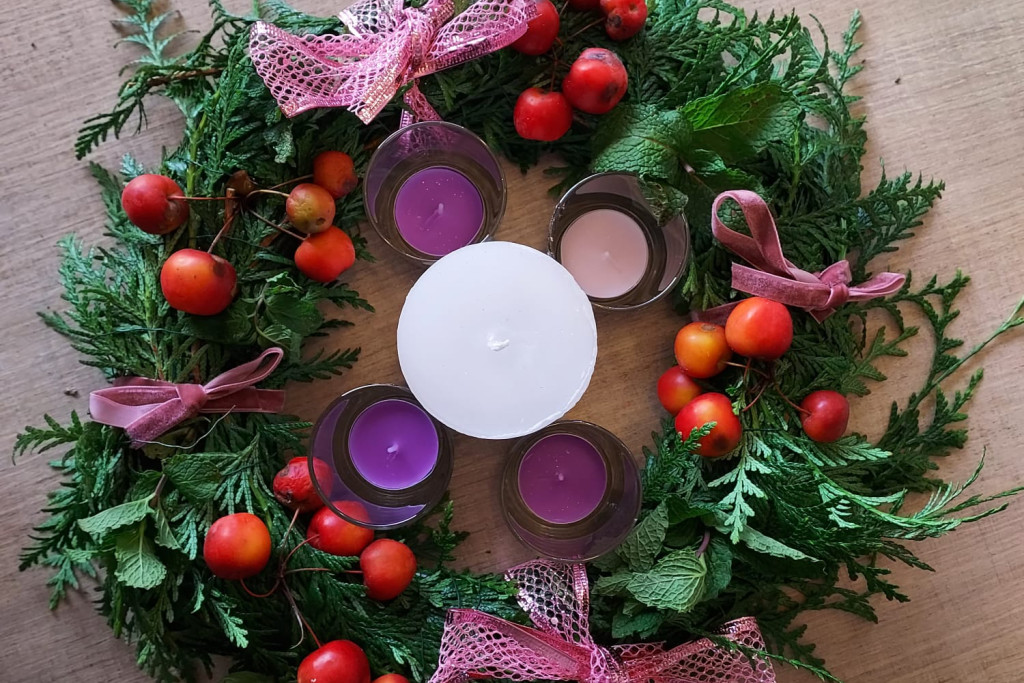 Een adventskrans zou je ook een verwachtingskrans kunnen noemen. Een adventskrans met drie paarse en één roze theelichtje rondom een centrale witte kaars.