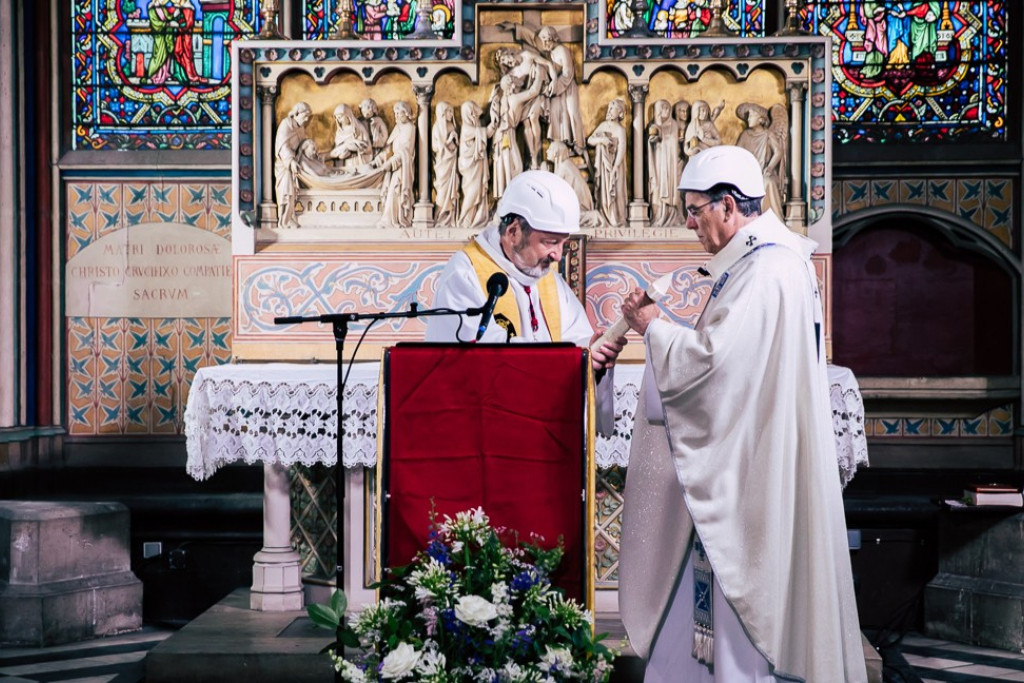 Mgr. Pascal Golnisch (links) overhandigt een kruis uit Aleppo aan mgr. Michel Aupetit (rechts) tijdens de eerste viering in de Notre-Dame na de brand.