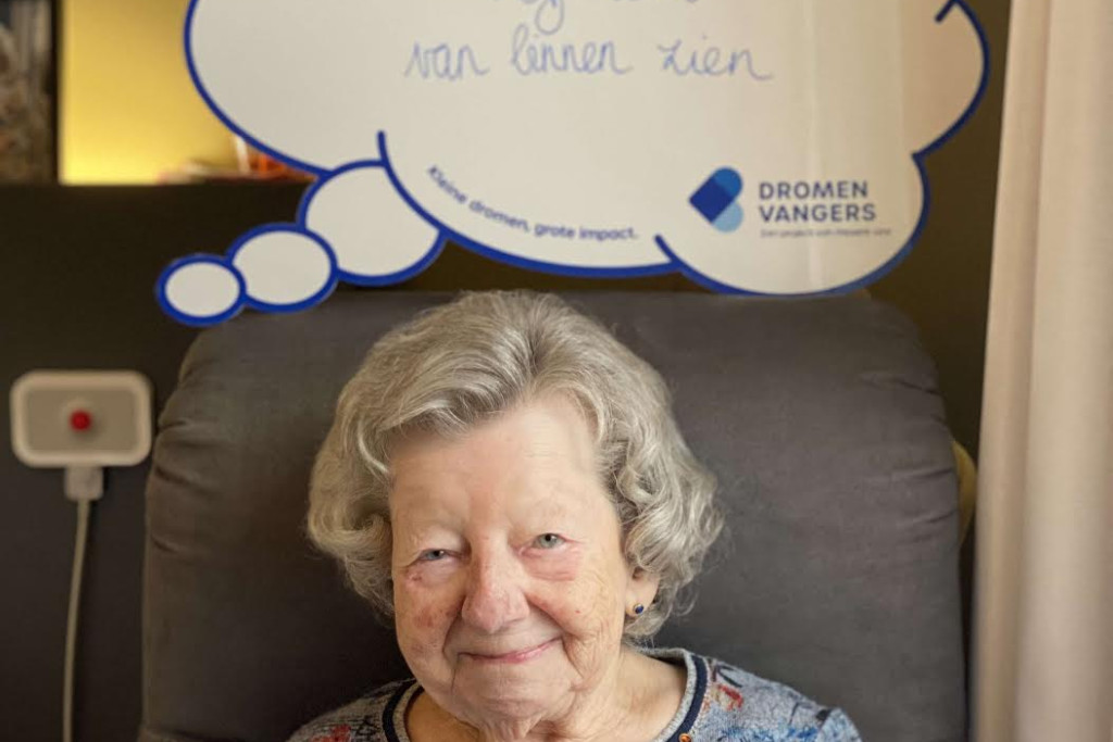 Betsy in het woonzorgcentrum. In een woordenwolk boven haar staat haar wens: nog één keer de Sint-Jacobskerk zien.