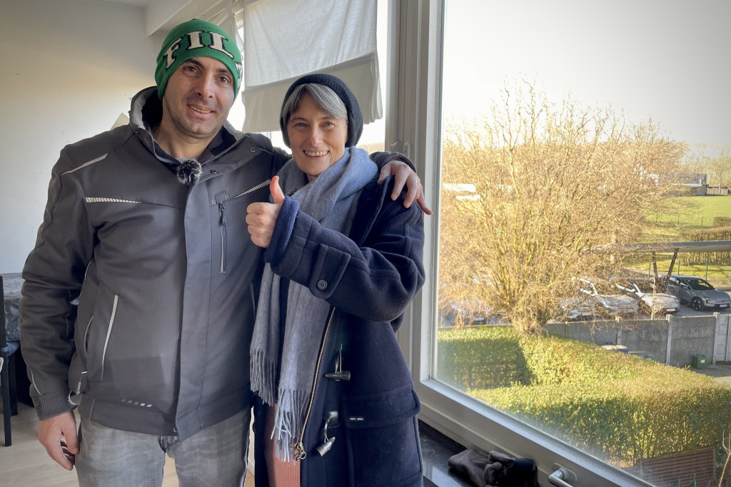 Na bijna tien jaar in ons land heeft Mehdi eindelijk een huurwoning gevonden. Parochieassistente Sanne Vermeeren steekt haar duim op naast Mehdi in zijn huurwoning.