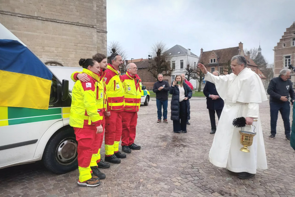 Pater Karel zegent aan de abdij van Grimbergen de ambulanciers en de ziekenwagen.