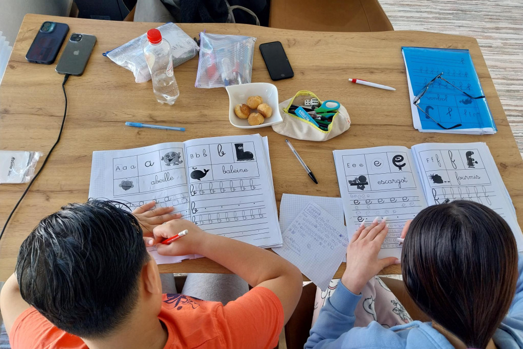 Twee kinderen oefenen krulletters. 