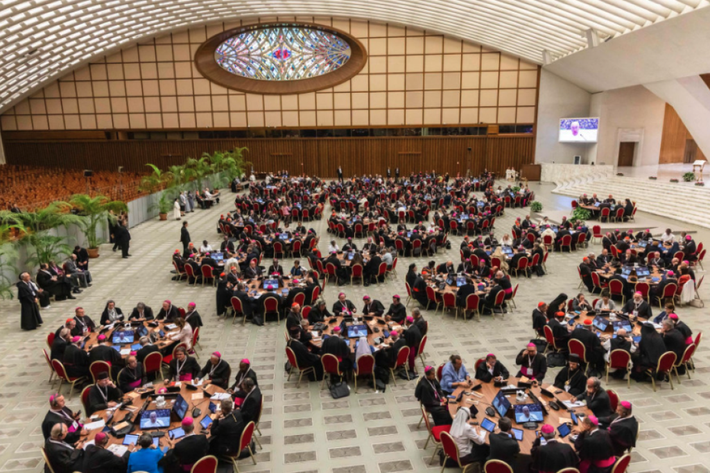 Ook dit is een foto van de paus: hij is één van tientallen deelnemers aan de synode, die verspreid over ronde tafels in de Paulus VI-zaal zitten. Ook dit is een foto van de paus: hij is één van tientallen deelnemers aan de synode, die verspreid over ronde tafels in de Paulus VI-zaal zitten.