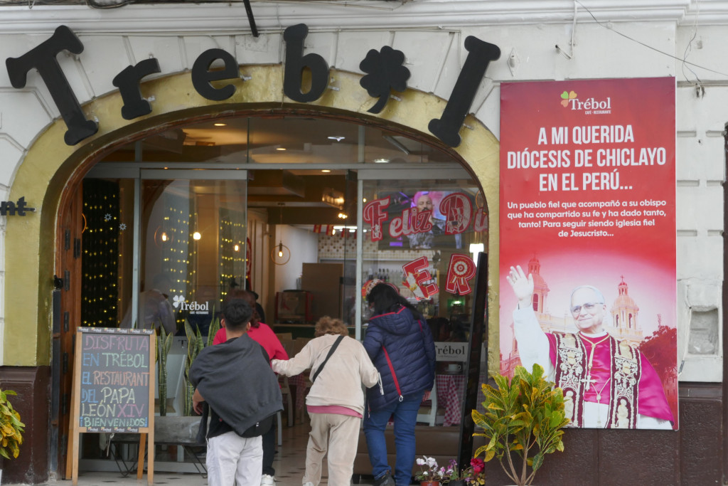 ‘Geniet in Trébol, het restaurant van Paus Leo XIV. Welkom!’, staat op het bord links. Rechts de groeten die Leo XIV als pas verkozen paus tot 'zijn geliefde bisdom' richtte.