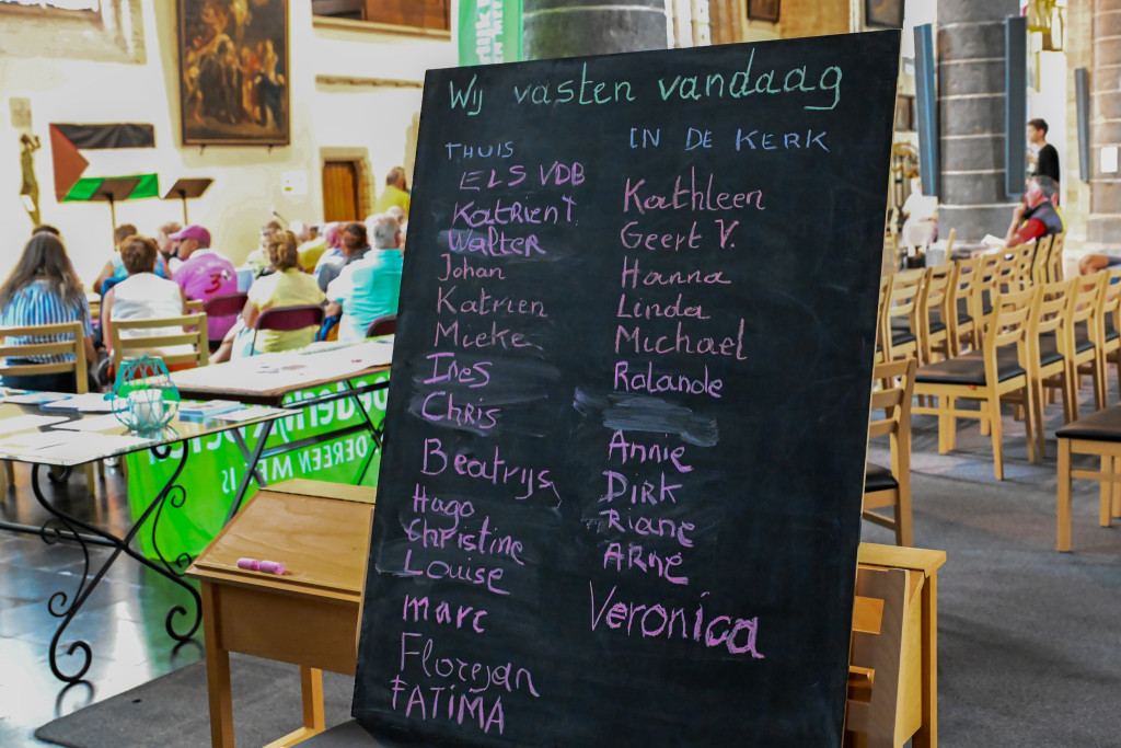 Op een krijtbord in de Sint-Pieterskerk in Ieper staan de namen van de bijna 30 mensen die meedoen aan de vijfdaagse hongerweek, thuis of in de kerk.