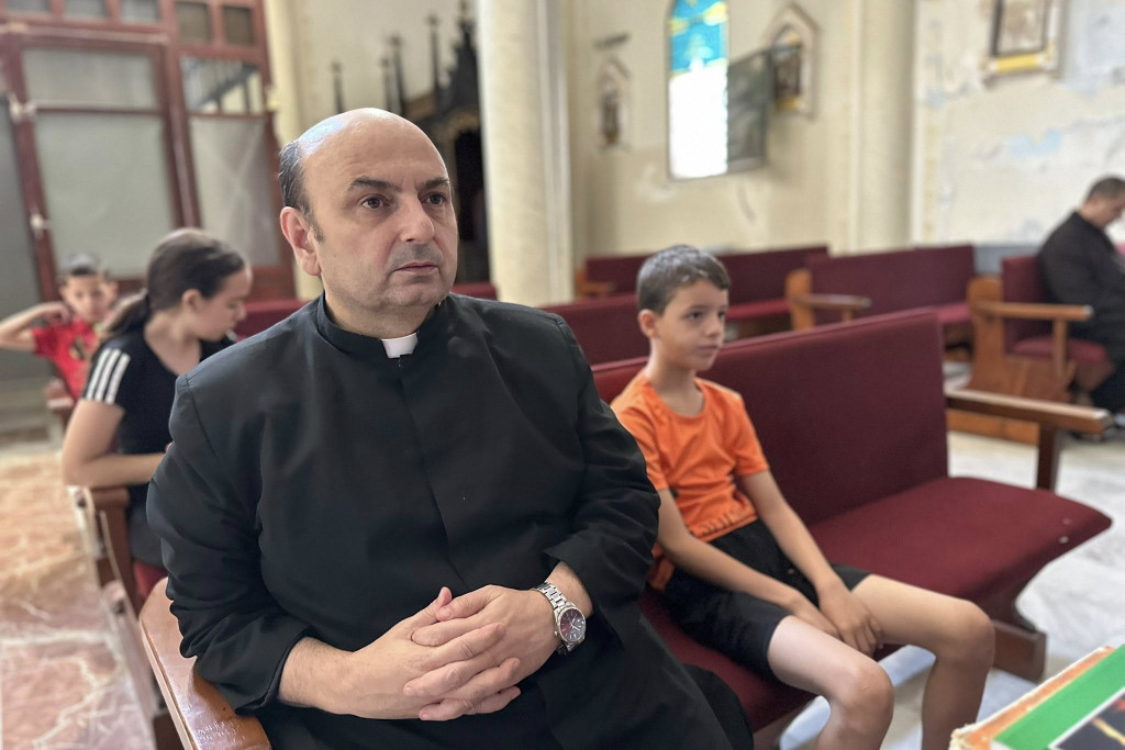 Pater Gabriel Romanelli in zijn kerk met enkele kinderen tijdens de catechese.