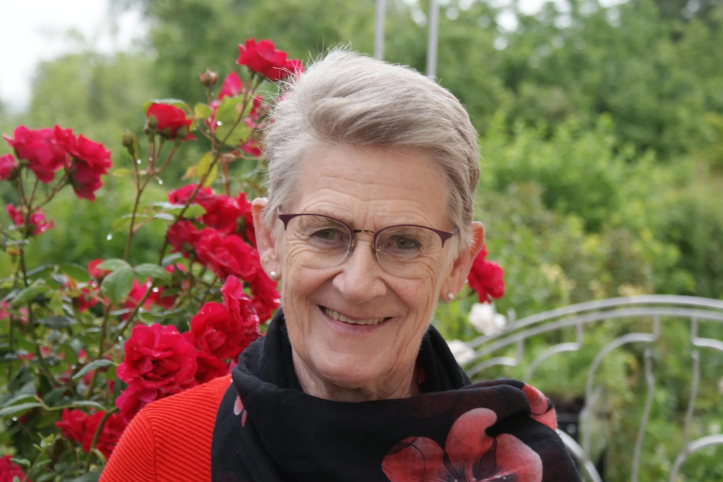 Portret Kris Gelaude met rode bloemen en truitje