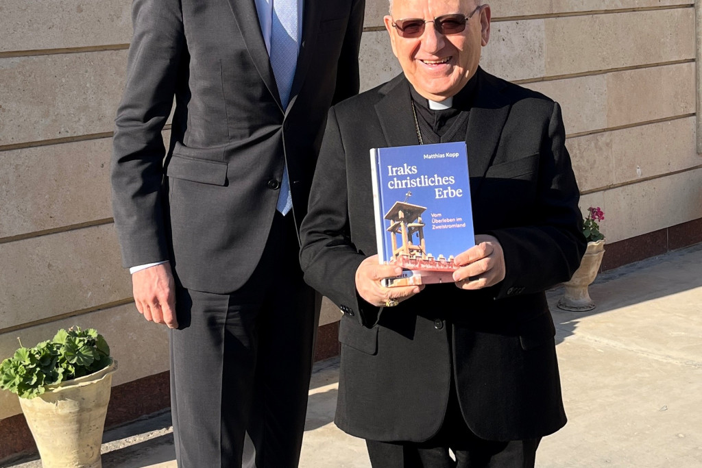 Matthias Kopp overhandigt in Bagdad een exemplaar van zijn boek aan de Chaldeeuwse patriarch en kardinaal Louis Raphaël Sako. 