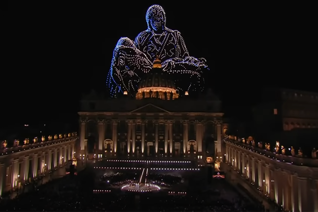 Drones beelden de Pietà van Michelangelo uit tegen de nachtelijke hemel boven het Sint-Pietersplein tijdens het event Grace for the World.