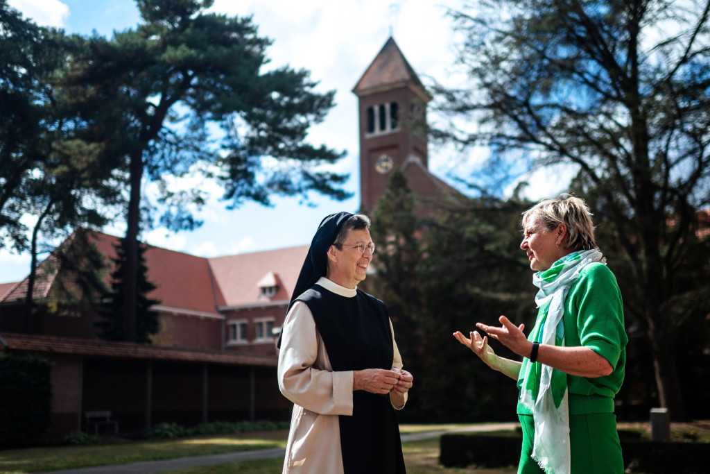 Annemie Struyf en zuster Katharina met de kerktoren van het klooster op de achtergrond.