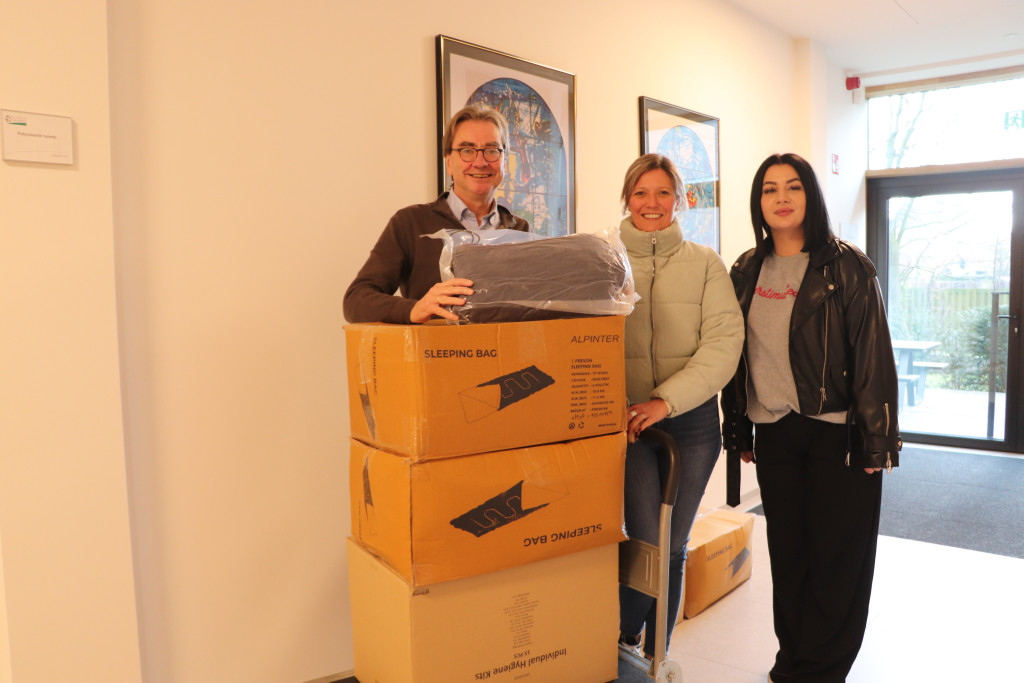 Bisschoppelijk gedelegeerde voor Diaconie en Caritas Frank Deloffer schenkt dozen vol slaapzakken en hygiënekits.