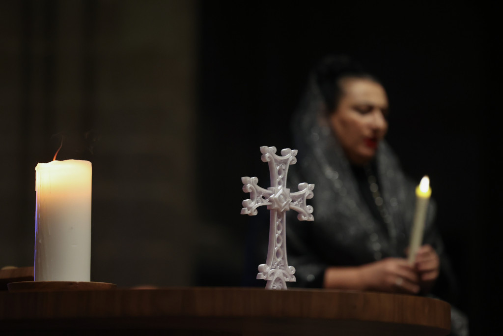 De Armeens-Apostolische Kerk legt in haar geloofsleer een nadruk op het licht van God en bid elke week voor alle christenen en voor de eenheid. Donker beeld met kruis en kaarsen tijdens een viering in de Armeens-Apostolische Kerk.
