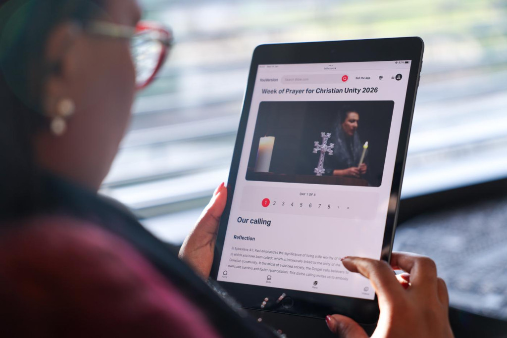 Vrouw kijkt op tablet naar een christelijke website (over de Gebedsweek voor de Eenheid).
