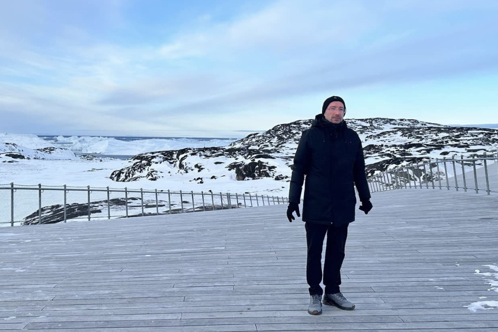 De Sloveense franciscaner missionaris Tomaž Majcen is sinds 2023 pastoor in Groenland. Pater Tomaž in zwarte winterkledij tegen de witte achtergrond van het sneeuwlandschap in Nuuk, Groenland.
