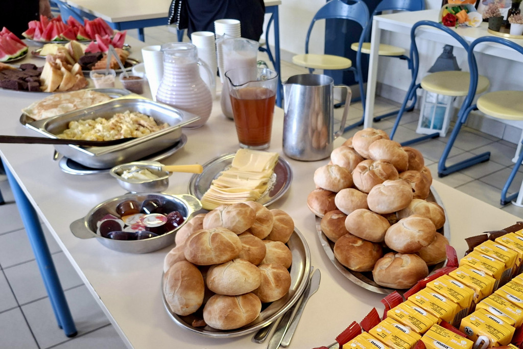 Caritas Hulpbetoon Vlaanderen ondersteunt 12 scholen in de strijd tegen lege brooddozen. Tafel met pistolets, chocomelk, fruit