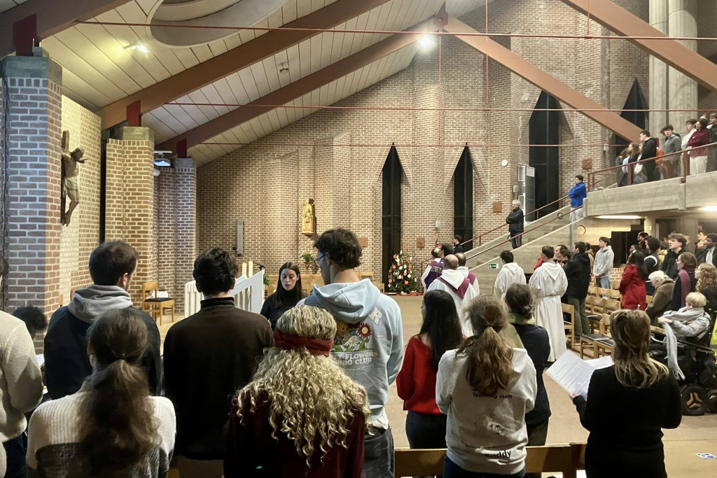 Beeld tijdens een studentenmis in de kerk van Sint-Franciscus van Assisi in Louvain-la-Neuve. Veel jong volk, moderne kerk.