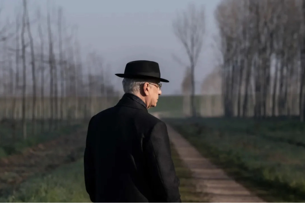 Toni Servillo in de rol van Mariano De Santis, president van Italië, in 'La Grazia' van Paolo Sorrentino. President van Italië (gespeeld door Toni Servillo), lange mantel en hoed, tegen mistige achtergrond.