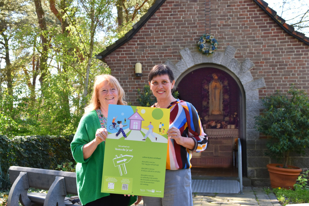 Ina Meliadó (links) en Marion Verweyen tonen aan de kapel het vertelpaneel.