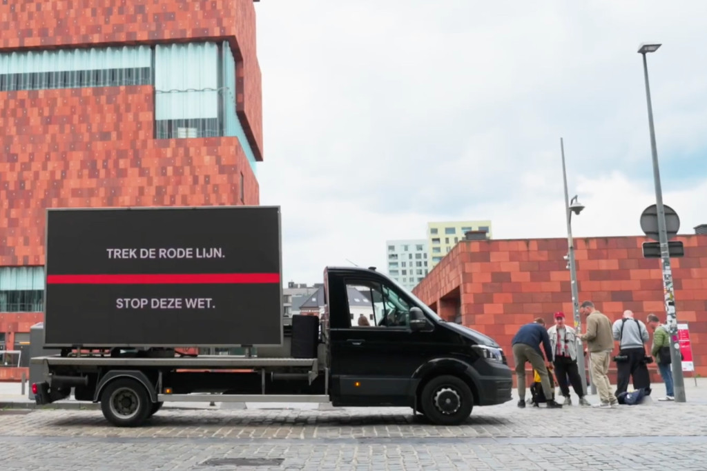 Truck met groot LED-scherm voor het MAS met boodschap: 'Trek de rode lijn.'