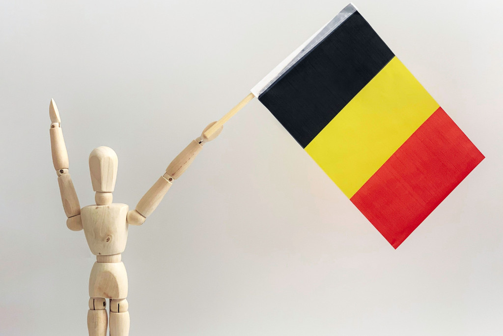 Houten ventje met Belgische vlag in de hand.