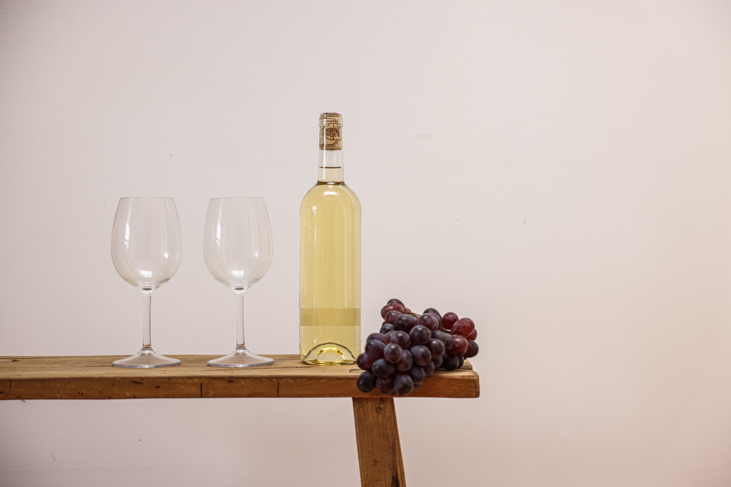 stilleven met fles witte wijn, twee glazen, een tros druiven