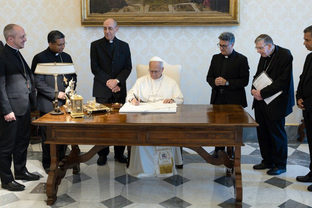 Paus Leo XIV ondertekent de nota 'A Journey of Hope' in aanwezigheid van de verantwoordelijken van de drie initiatiefnemende dicasteries.