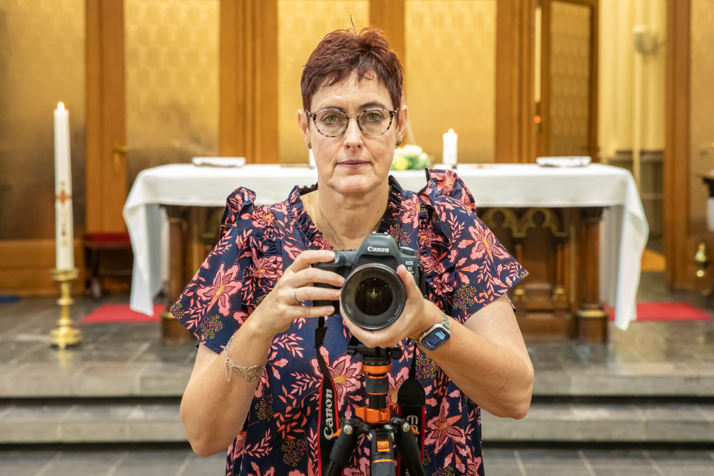 Diana Nieuwold kijkt geconcentreerd in de camera, terwijl ze in het midden van de foto zelf haar fotocamera op 'het vogeltje' richt.
