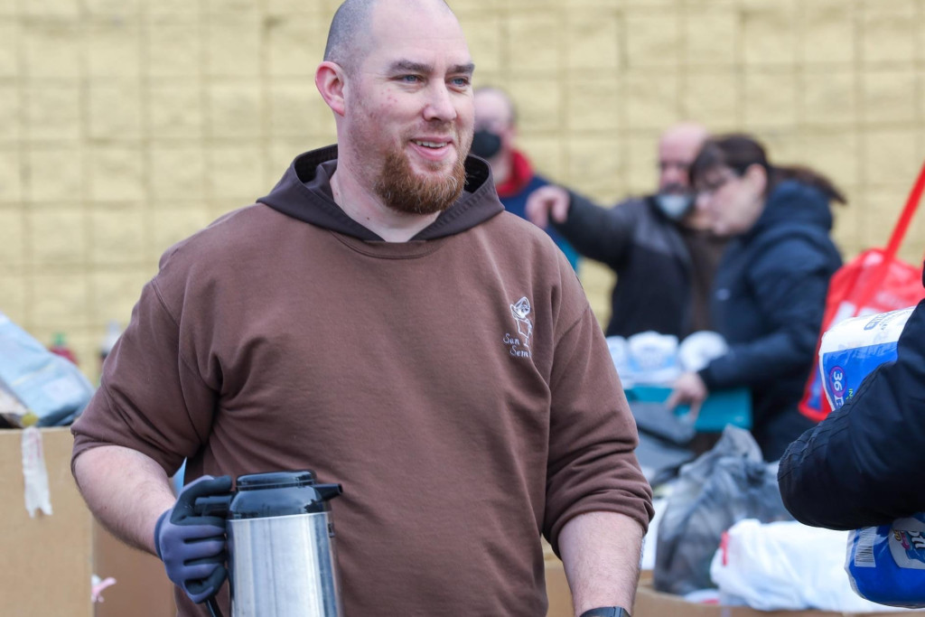 Igor De Bliquy in kapucijnerpij en met een koffiekan in de hand, aan het werk in de soepkeuken van de kapucijnen in Detroit.